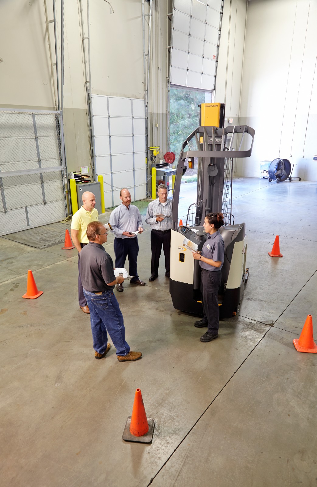 Warehouse employees receiving hands-on forklift training with a Crown lift truck in a training session