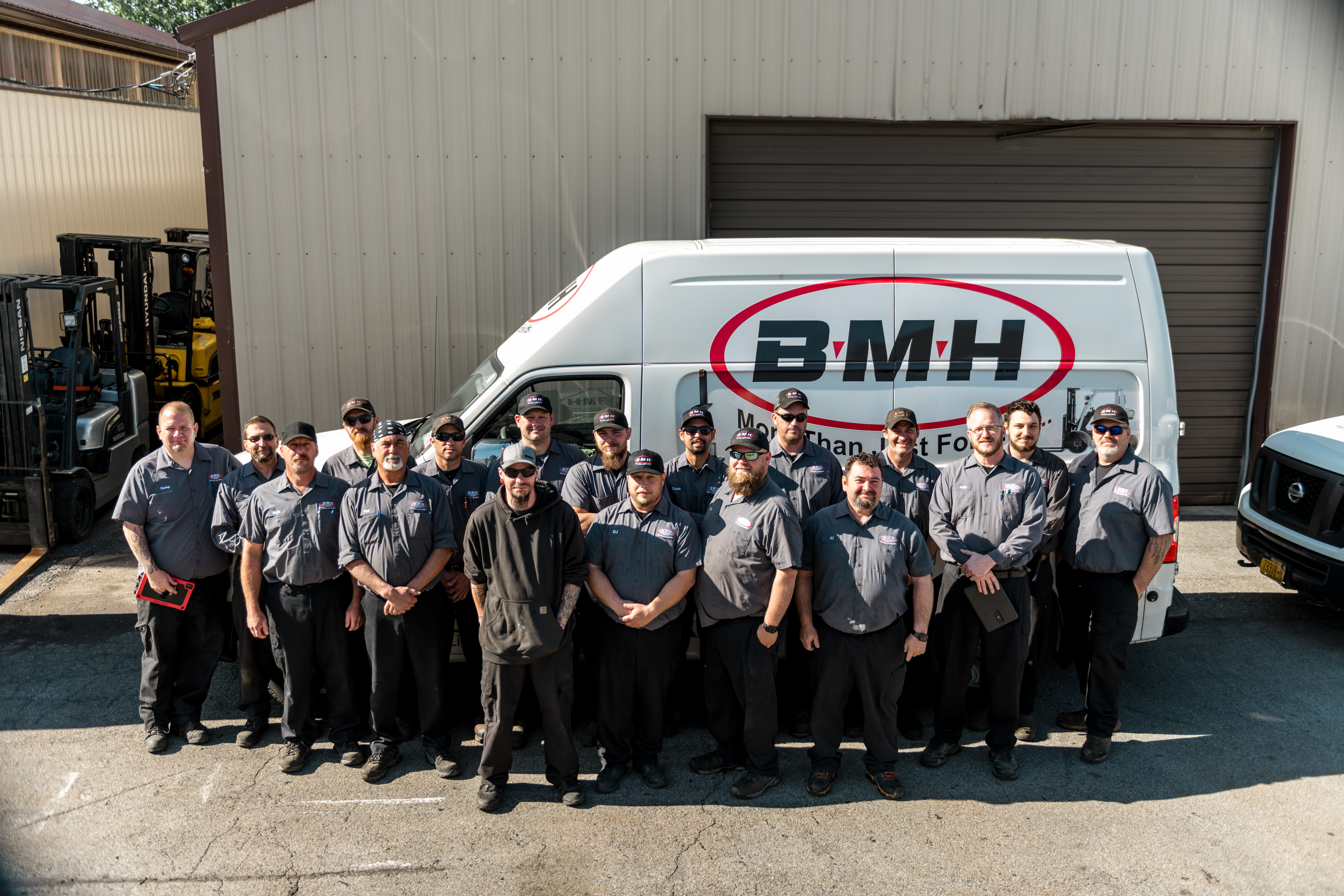 BMH Buffalo Materials Handling service team standing in front of a company van, dedicated to quality service